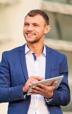 happy-businessman-with-a-tablet-2021-08-31-17-05-24-utc-Custom-e1643091634402.jpg